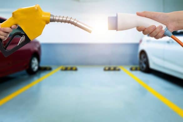 Human hands holding electric plug and gasoline nozzle