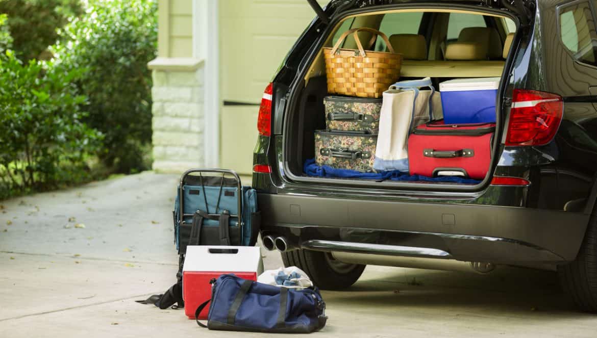 Family sport utility vehicle packed up and ready to go on summer road trip or vacation. Outside house.