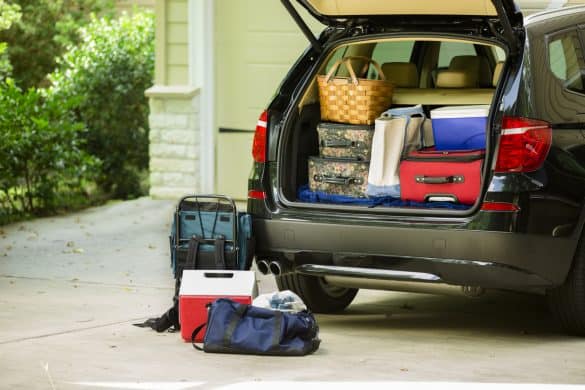 Family sport utility vehicle packed up and ready to go on summer road trip or vacation. Outside house.