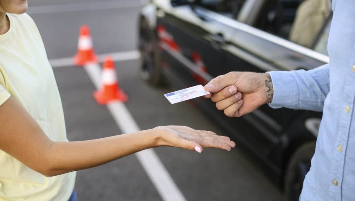 Young woman learning how to drive a car. About 20 years old, Caucasian female and a mid adult male driving instructor.